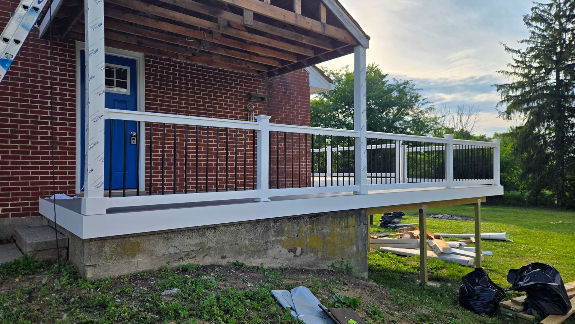 Composite deck build in progress with white vinyl railing