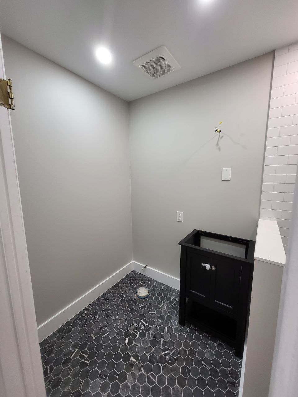 Nearly finished bathroom remodel with black vanity