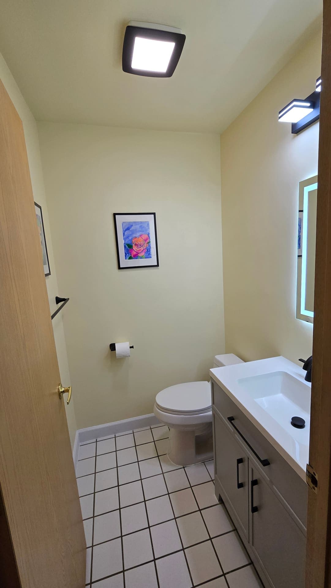Finished bathroom with skylight and white tile floor