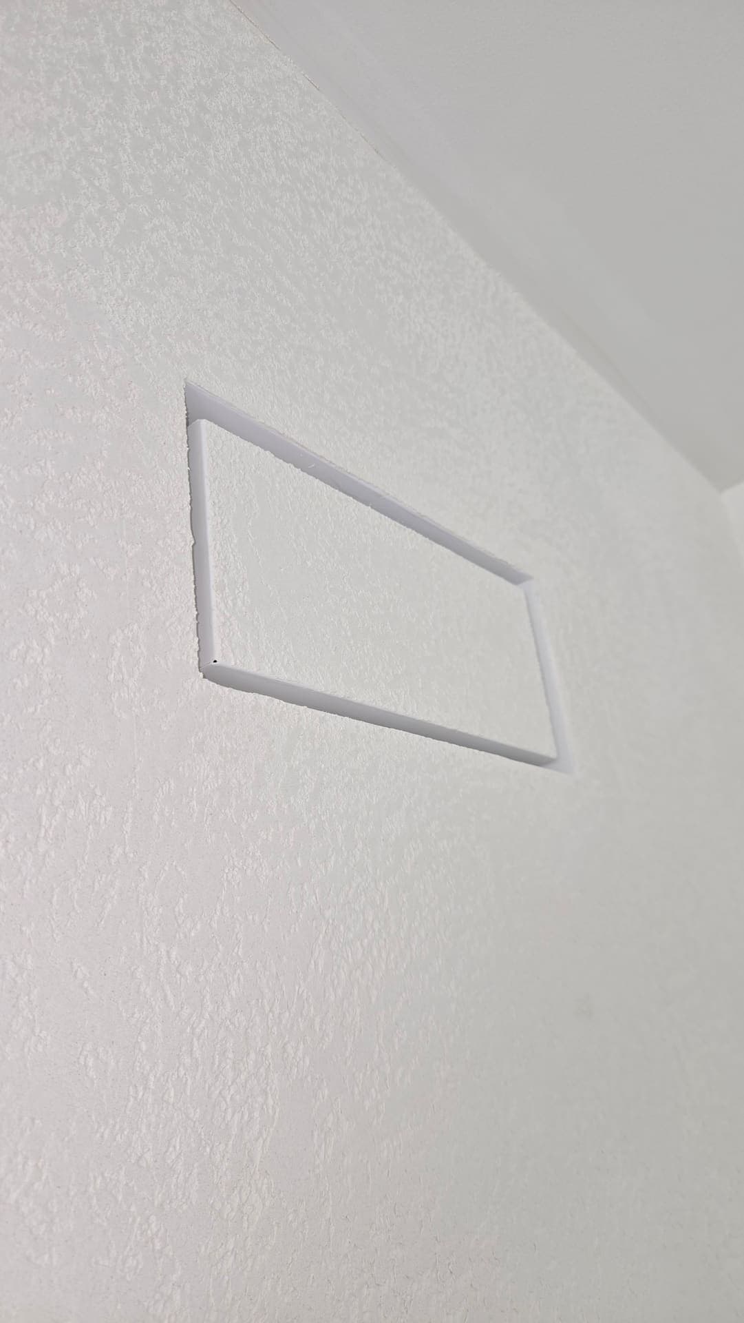 Flush recessed access panel in a textured ceiling
