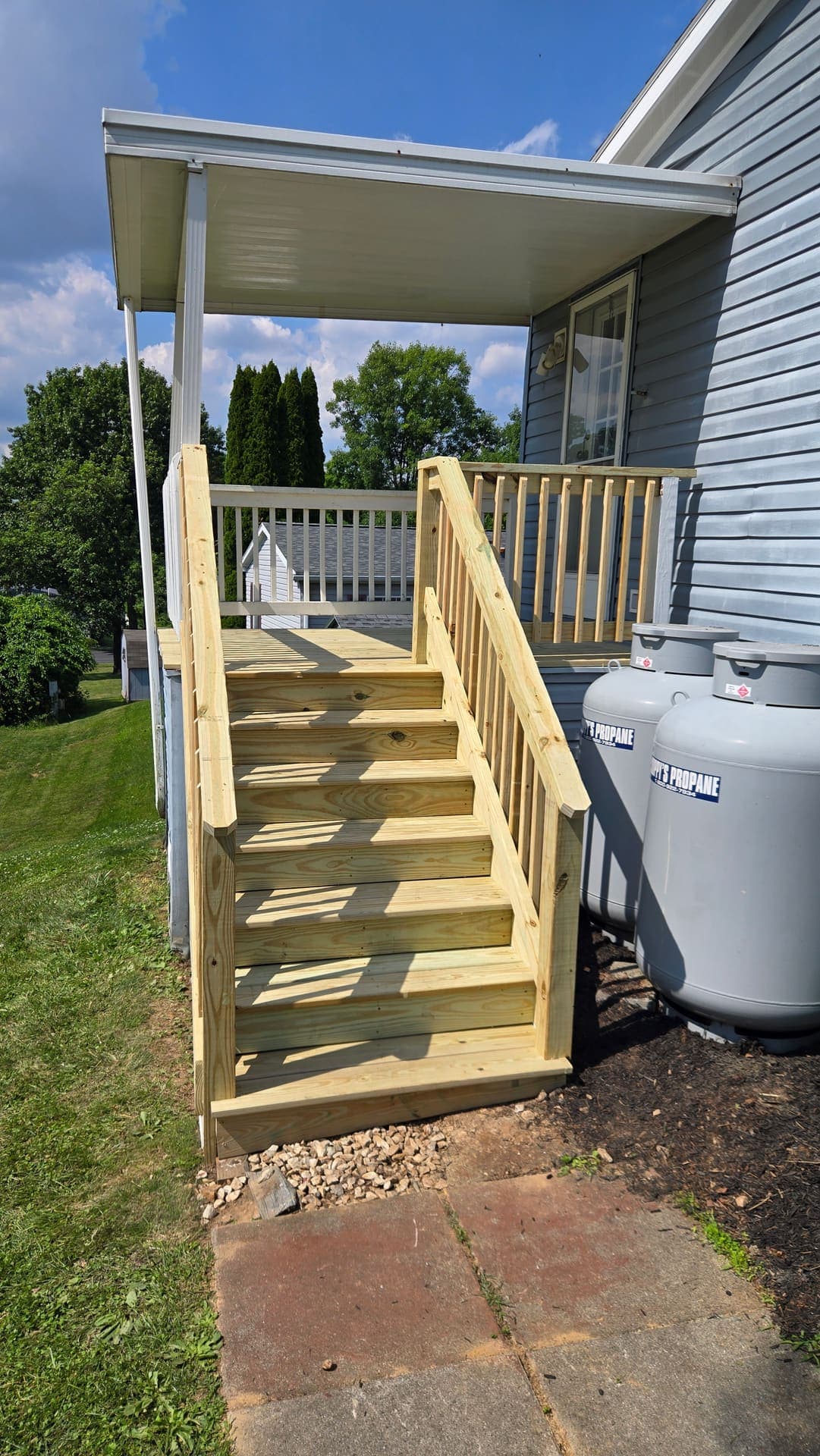 New treated wood stairs at a side entrance